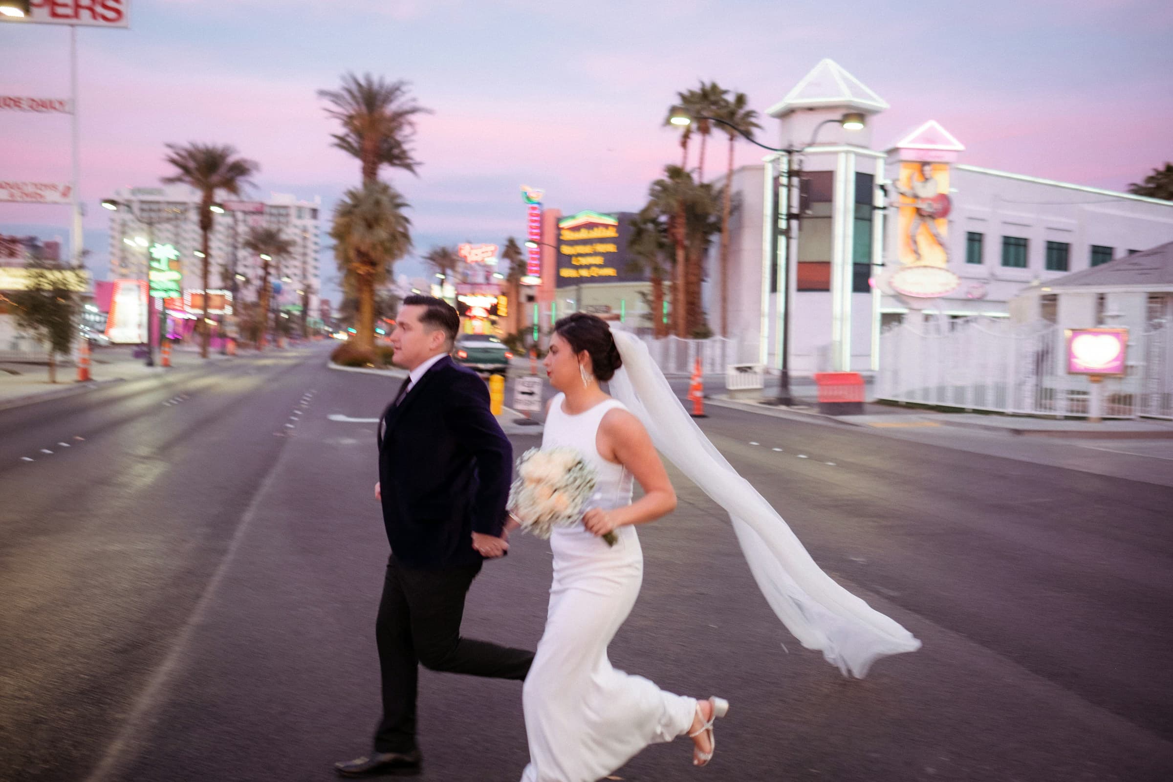 A couple eloping outdoors, laughing with their small group of guests