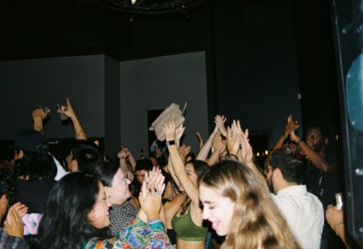Crowd dancing and cheering at an indoor party